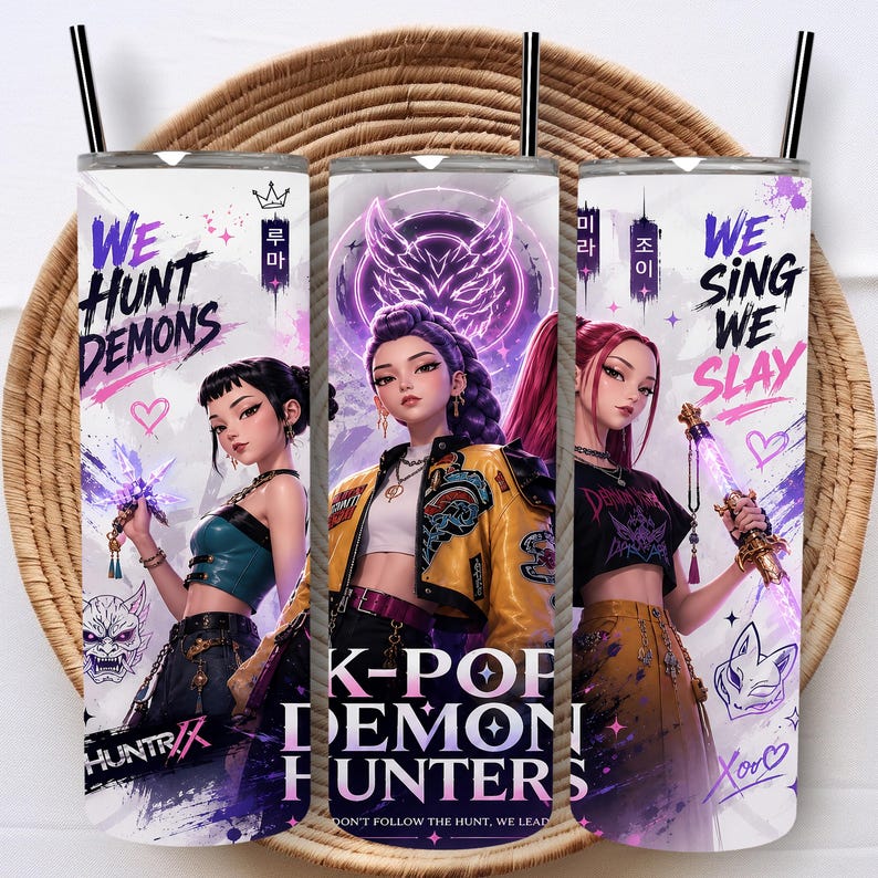 May include: Three cylindrical tumblers with black straws featuring anime-style characters and text. The designs include the phrases "WE HUNT DEMONS," "K-POP DEMON HUNTERS," and "WE SING WE SLAY" alongside purple and yellow accents, hearts, and masks.