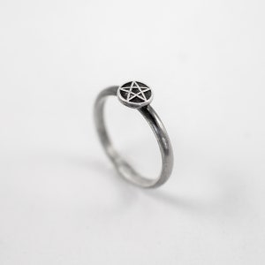 May include: A silver ring featuring a five-pointed star design.