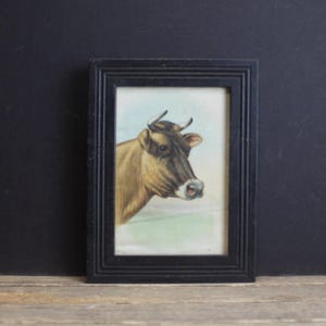 Vintage ingelijste koeienwand hangend boerderijhuis