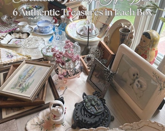 May include: A selection of antique items, such as framed pictures, teacups, decorative plates, and a Matryoshka doll. The image is labelled "Curated Vintage Gift Box" with the text "6 Authentic Treasures in Each Box" and "6 Authentic Vintage or Antiques in Each Gift Box".