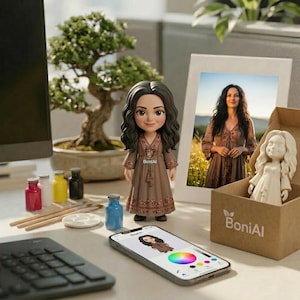 May include: A figurine of a woman in a brown dress with a matching phone screen, a framed photo, and a box with a white figurine. The scene includes paint bottles, brushes, and a bonsai tree. The phone displays a color palette.