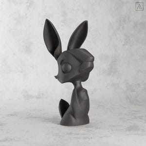 May include: A dark gray, stylized sculpture of a rabbit-like creature with large ears and a slender body. The figure is posed in a seated position, with its head turned to the side. The sculpture has a smooth, matte finish and is set against a neutral background.