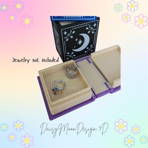 May include: A white ceramic mug with a black handle and the text "But First, Coffee" in a bold, black font. The mug is set against a blurred background, suggesting a cozy setting.