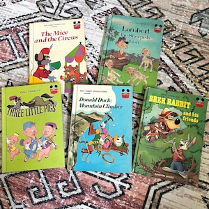May include: A collection of five vintage children's books featuring Disney characters. The books are titled "The Mice and the Circus", "Lambert the Sheepish Lion", "Three Little Pigs", "Donald Duck: Mountain Climber", and "Brer Rabbit and his Friends".
