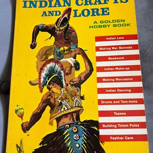 May include: A vintage book titled "Indian Crafts and Lore" by W. Ben Hunt. The cover is yellow with illustrations of Native American figures. The book includes topics like Indian Lore, Beadwork, and Making Moccasins.