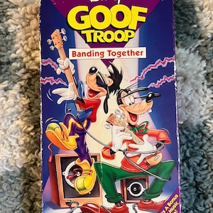 May include: A vintage VHS tape for Disney's Goof Troop, titled "Banding Together." The cover features Goofy and Max playing guitars in front of speakers. The tape is in a purple, blue, and red color scheme.