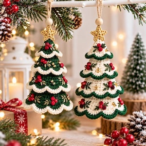 May include: Two hanging crochet Christmas tree ornaments, one dark green and one cream, each topped with a gold star and a wooden bead. Both trees feature scalloped edges, embroidered green leaves, red berry clusters, and small gold beads.