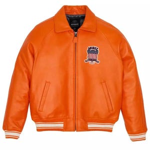 May include: Bright orange leather jacket with a zip closure, collar, and two front pockets. The jacket has white and red striped trim on the cuffs and hem. A chest patch displays the text "AVIREX" and a patriotic emblem.