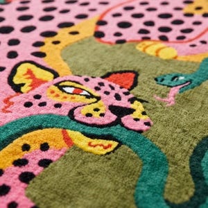 Peut inclure: Un tapis textile touffet&eacute; repr&eacute;sentant un l&eacute;opard rose &agrave; taches noires avec des accents jaunes, entrelac&eacute; avec un serpent vert sur un fond vert olive. Le motif comprend une seconde figure de l&eacute;opard rose dans la partie sup&eacute;rieure du tapis.