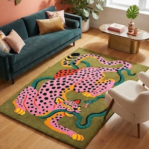 Peut inclure: Un tapis rectangulaire au fond vert olive orn&eacute; d'un grand l&eacute;opard rose stylis&eacute; couvert de taches noires. Le l&eacute;opard est repr&eacute;sent&eacute; dans une pose dynamique, interagissant avec un long serpent vert fonc&eacute; sinueux.