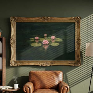 May include: A rectangular painting in an ornate gold frame depicting pink water lilies floating on dark green water. The artwork features several blooming flowers and lily pads with soft reflections on the water surface, presented in a landscape orientation.