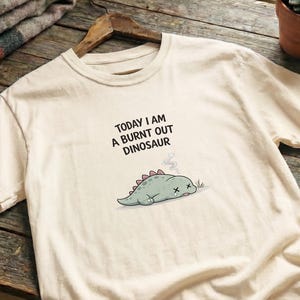 Cute burnout tee with soft pastel dinosaur illustration on premium Comfort Colors fabric