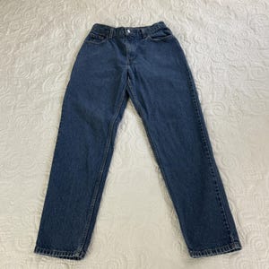 May include: A pair of blue denim jeans. The jeans have a classic five-pocket design, a button and zipper closure, and a straight leg cut. The denim is a medium wash, and the jeans appear to be in good condition.