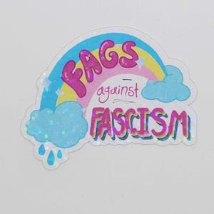May include: A sticker featuring a rainbow design with the words "Fags against Fascism." The text is in bubble letters with a holographic effect. The sticker also includes blue clouds and raindrops.