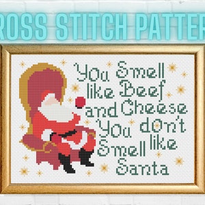 May include: Cross stitch pattern featuring a cartoon Santa Claus sitting on a throne with the text "You Smell like Beef and Cheese You don't Smell like Santa".