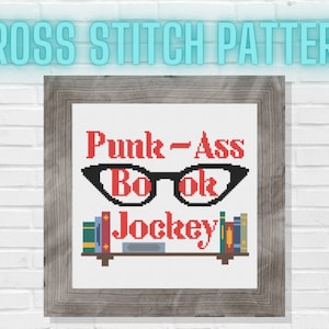 May include: Cross stitch pattern featuring the text "Punk-Ass Book Jockey" in red lettering, a pair of black spectacles, and a bookshelf with books in red, green, and blue.