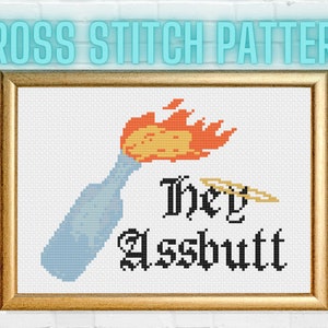 Könnte beinhalten: Kreuzstichmuster mit einer blauen Flasche mit einer gelben und orangenen Flamme oben. Der Text "They Assbutt" ist in schwarzer gotischer Schrift.
