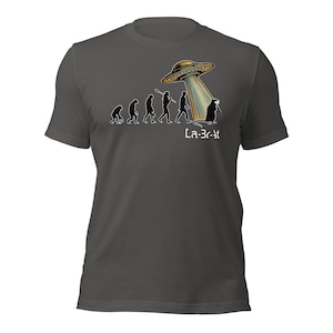 May include: Dark gray t-shirt featuring a humorous graphic of human evolution, culminating in an alien abduction. The design includes a UFO and the text "La-Br-At".