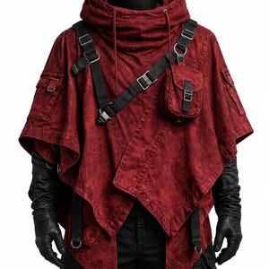 May include: A dark red hooded poncho featuring a distressed fabric texture, black adjustable nylon straps with metal buckles, and a small utility pocket on the chest. The garment includes side pockets and a high collar with drawstring cords.
