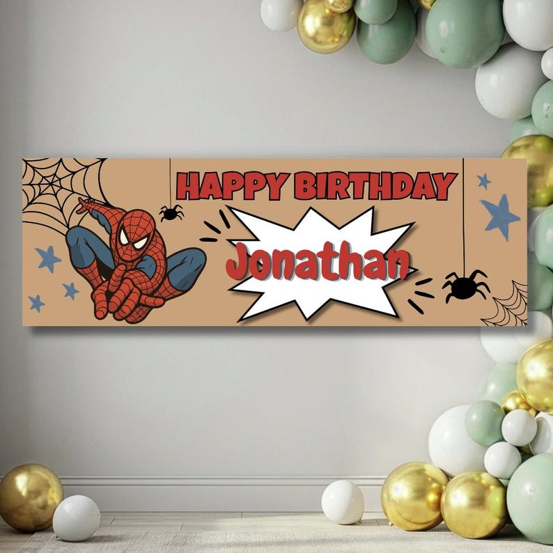 May include: A rectangular tan birthday banner featuring a red and blue Spider-Man character, black spider webs, and small blue stars. The text reads HAPPY BIRTHDAY in red letters, with the name Jonathan in red inside a white comic book style burst.