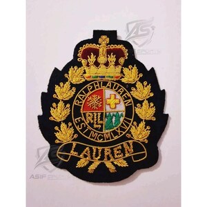 May include: A black embroidered patch featuring a gold crown at the top and a central circular crest divided into four quadrants with red, white, and green details. The text RALPH LAUREN EST MCMLXVII is stitched in gold, with LAUREN on a banner below.