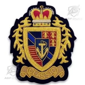 May include: A dark blue embroidered patch featuring a gold crown at the top, a central shield with a gold anchor, and red and blue sections. The shield is surrounded by gold foliage, and a gold banner at the bottom displays the text CLASSIC.