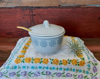 Vintage stoneware sugar bowl with sunburst pattern and Tupperware spoon.