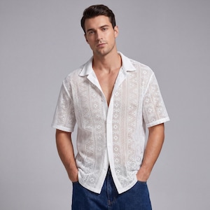 May include: White short-sleeve shirt with an open collar and a geometric lace pattern. The shirt is buttoned down the front and paired with blue jeans. The shirt's design features diamond and vertical stripe patterns.
