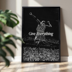 May include: A black and white framed wall art print featuring a basketball player in a jersey with the number 23 jumping in the air. The text Give Everything is printed in white in the center of the image above a crowded stadium arena.