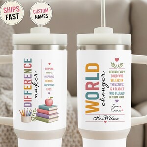 May include: Two white stainless steel tumblers with handles and straws. The left tumbler features the text "DIFFERENCE maker" with a stack of books, an apple, and the phrase "SHAPING MINDS. INSPIRING HEARTS. IMPACTING LIVES." The right tumbler displays "WORLD changer" and the text "BEHIND EVERY CHILD WHO BELIEVES IN THEMSELVES IS A TEACHER WHO BELIEVED IN THEM FIRST." with "Love, Emma" and "Mrs. Wilson."