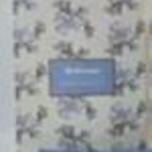 May include: A blue notebook with the word "Notebook" on the cover, set against a floral wallpaper background. The wallpaper features a repeating pattern of white and gray flowers.
