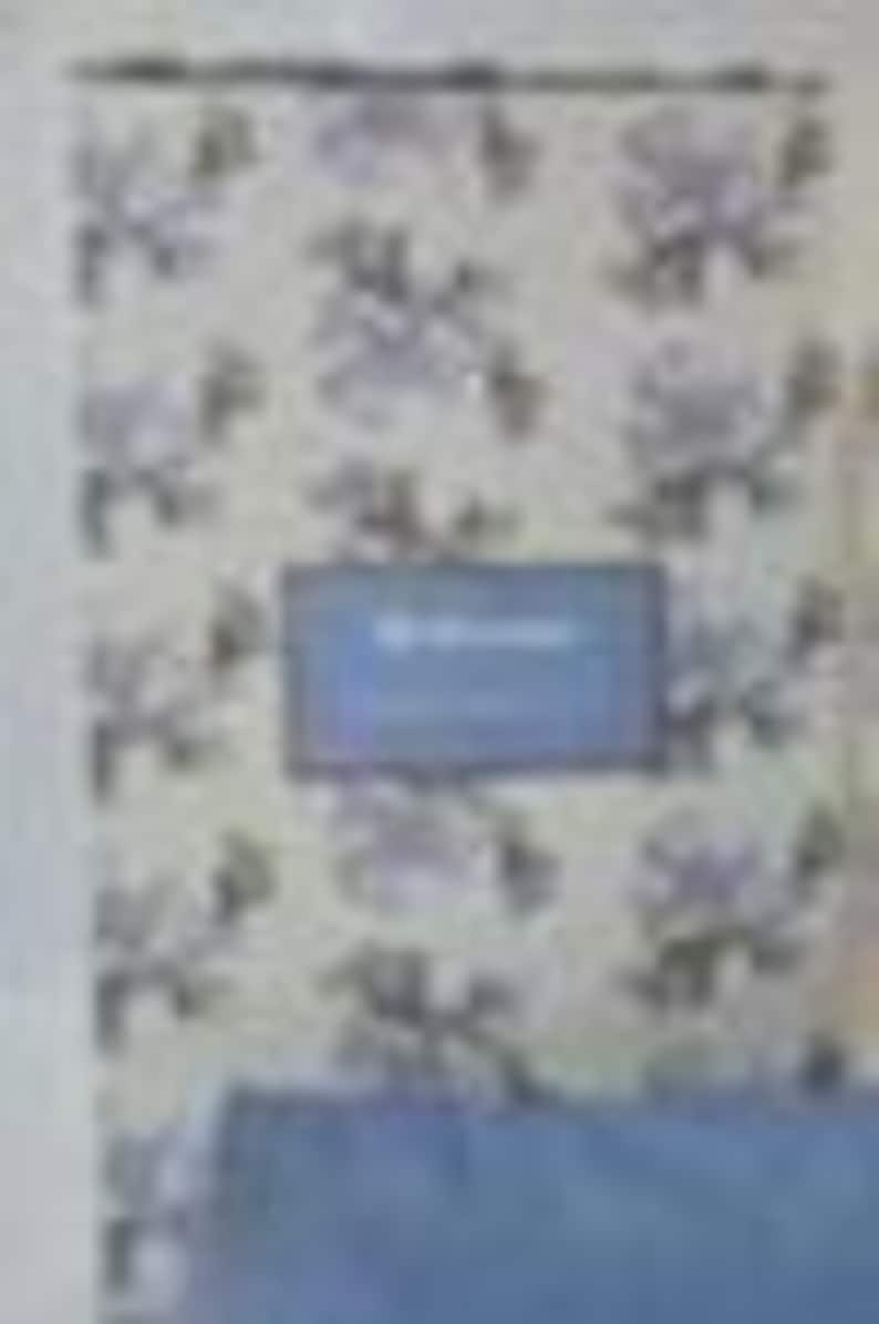 May include: A blue notebook with the word "Notebook" on the cover, set against a floral wallpaper background. The wallpaper features a repeating pattern of white and gray flowers.