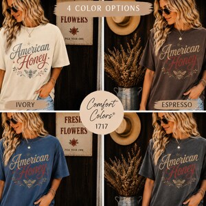 May include: Four short-sleeved t-shirts in ivory, espresso, blue, and grey. Each shirt displays the text "American Honey" with a bee graphic. The shirts have a vintage style. The image also includes the text "Comfort Colors 1717".