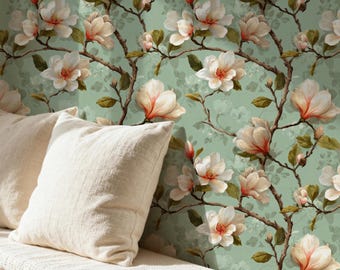 May include: A bench with two cream-colored pillows in front of a floral wallpaper. The wallpaper features a repeating pattern of magnolia flowers in shades of white, peach, and brown against a light green background. The flowers are on brown branches with green leaves.