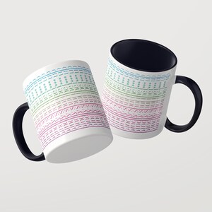 Puede incluir: Dos tazas de cer&aacute;mica blanca con asas e interiores negros. La superficie exterior presenta l&iacute;neas horizontales repetitivas de texto que dicen "sunshine" en un degradado de azul, verde, rosa y morado, intercaladas con peque&ntilde;os s&iacute;mbolos de asterisco.