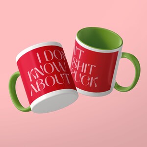 May include: Two ceramic mugs with a red exterior and a green interior and handle. The mug on the left features the white text I DON'T KNOW ABOUT. The mug on the right features the white text SHIT FUCK. Both mugs have a smooth, glossy finish.