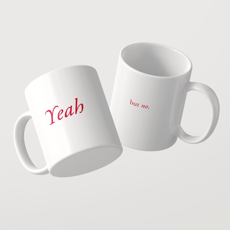 May include: Two white ceramic mugs with handles. One mug features the word "Yeah" in red script font. The second mug, positioned slightly behind and to the right, displays the text "but no." in smaller red font on its side.