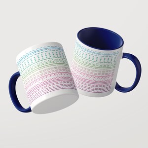 Puede incluir: Dos tazas de cer&aacute;mica blanca con interior y asa de color azul oscuro. La superficie exterior presenta l&iacute;neas horizontales repetitivas de texto que dicen "sunshine" en un degradado de colores azul claro, verde, rosa y morado, con peque&ntilde;as estrellas.