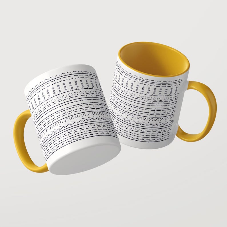 Puede incluir: Dos tazas de cer&aacute;mica blanca con asas e interiores de color amarillo brillante. La superficie exterior de cada taza presenta el texto negro repetido "shut the f*** up" en filas horizontales, creando un patr&oacute;n repetitivo sobre el cuerpo blanco.