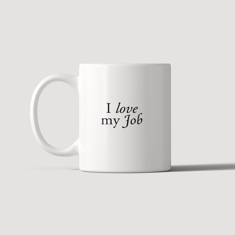 May include: A white ceramic mug with a C-shaped handle featuring the black text "I love my Job" printed in a serif font on the front. The mug has a smooth, cylindrical body and a clean, minimalist design suitable for holding hot or cold beverages.