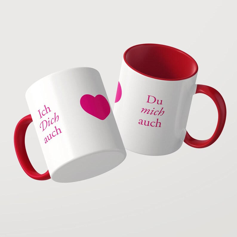 Pu&ograve; includere: Due tazze in ceramica bianca con interno e manico rossi. Le tazze presentano una scritta color magenta che recita Ich Dich auch e Du mich auch, accompagnata da un cuore magenta. Il design &egrave; stampato sulla superficie esterna delle tazze.