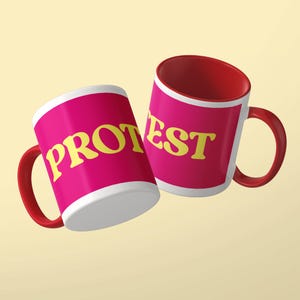 May include: Two ceramic mugs with a bright pink exterior and a deep red interior and handle. The mug on the left features the yellow text PROT, while the mug on the right displays the yellow text EST. Both mugs have a white rim and base.