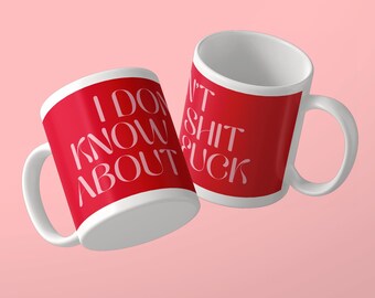 May include: Two white ceramic mugs with red exterior panels. The left mug features the white text I DON'T KNOW ABOUT. The right mug features the white text I DON'T SHIT FUCK. Both mugs have a curved handle and a smooth, glossy finish on the surface.