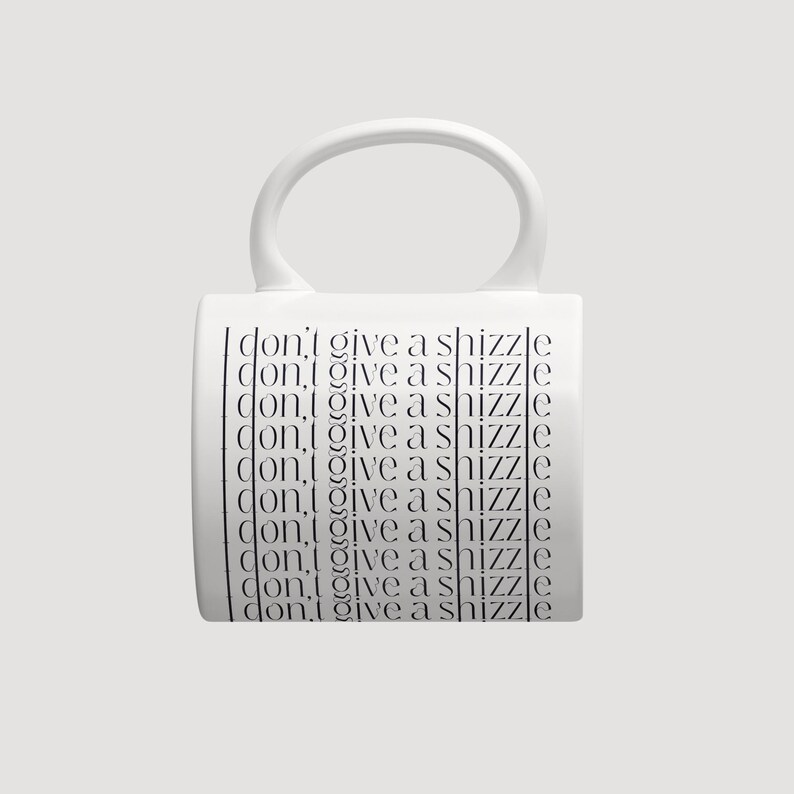 K&ouml;nnte beinhalten: Ein wei&szlig;er Keramikbecher mit einem gro&szlig;en, abgerundeten Henkel und einem sich wiederholenden schwarzen Textdesign. Der Satz "i don't give a shizzle" ist in einer d&uuml;nnen, serifenlosen Schrift neunmal vertikal auf der Vorderseite des Bechers gedruckt.
