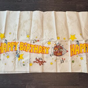 May include: A white ceramic mug with a black handle and the text "But First, Coffee" in a black, handwritten-style font. The mug is on a white surface.