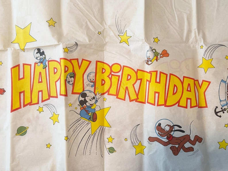 May include: A white ceramic mug with a black handle and the text "But First, Coffee" in a black, handwritten-style font. The mug is on a white surface.