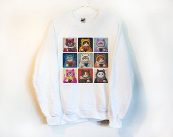 May include: White sweatshirt with a graphic print of nine cats wearing different colored hats and holding mugs. Each cat is in a separate square.