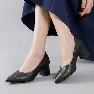 以下が含まれることがあります： ポインテッドトゥとブロックヒールが特徴の黒革パンプス。クラシックなデザインで、様々なシーンに合わせやすいです。ヒールは約6.35cmです。