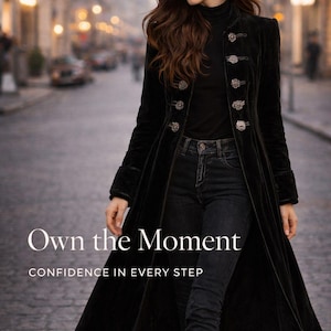 May include: A long black velvet coat with ornate silver buttons. The coat is worn over a black turtleneck and dark jeans. The image includes the text "Own the Moment" and "CONFIDENCE IN EVERY STEP".