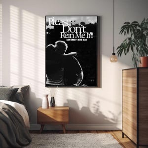 Puede incluir: L&aacute;mina art&iacute;stica enmarcada en blanco y negro con el texto "Please Don't Rein Me In" y los nombres "Sam Fender" y "Olivia Dean". La imagen muestra una silueta de dos personas abraz&aacute;ndose. Decoraci&oacute;n de pared.